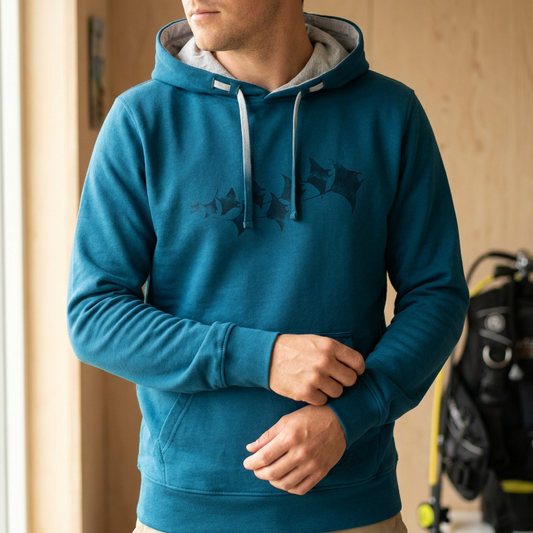 Mann im Manta Rays Hoodie in Lyons Blue vor Tauchausrüstung
